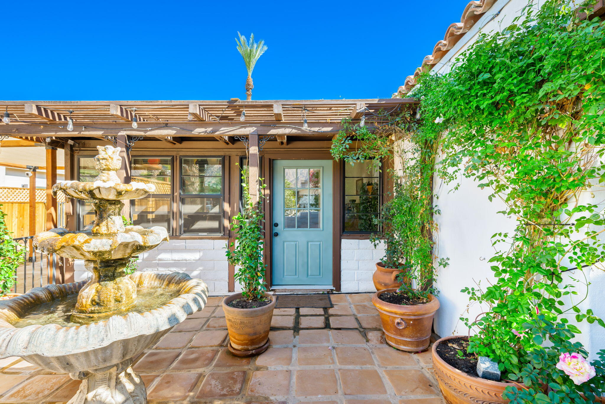 a view of a patio with table and chairs potted plants