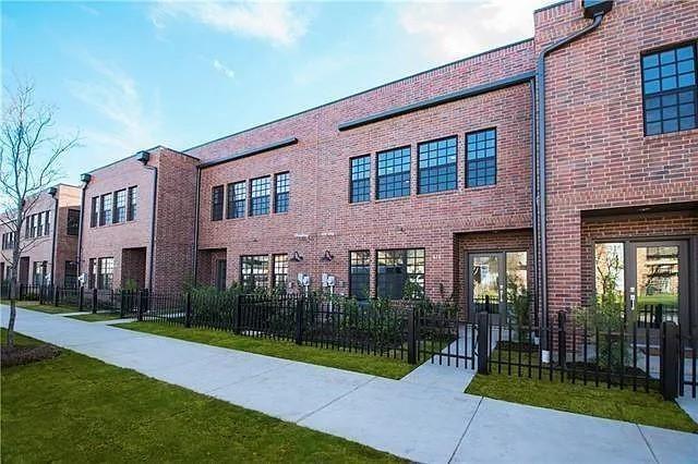 a view of brick building with a yard