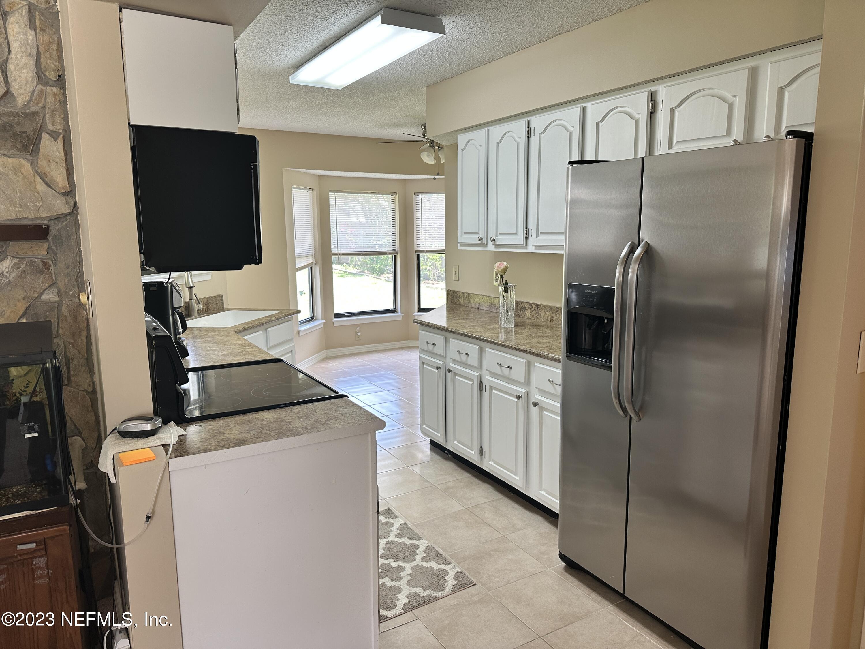 a kitchen with stainless steel appliances granite countertop a refrigerator and a fireplace