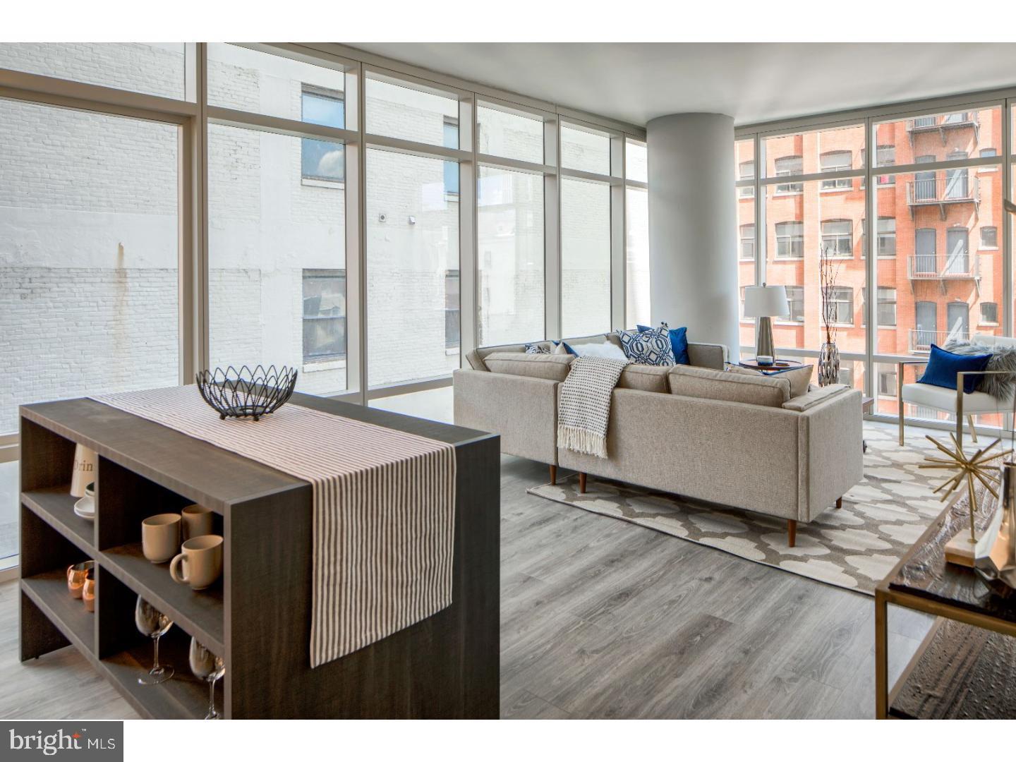 a living room with furniture and large windows