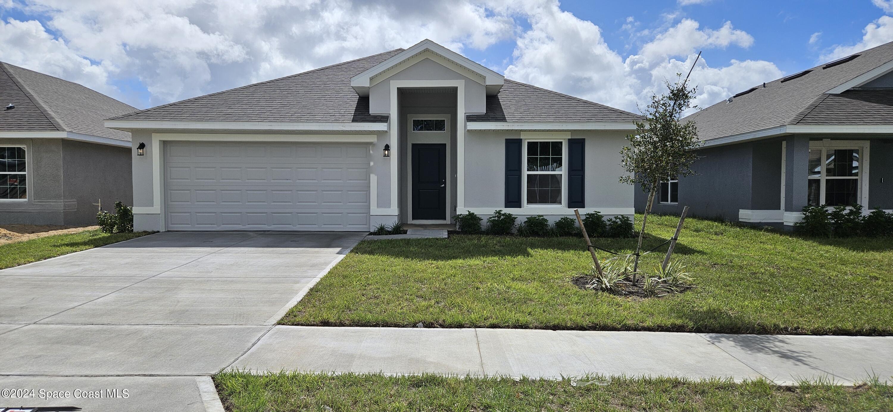 a front view of a house with a yard and garage