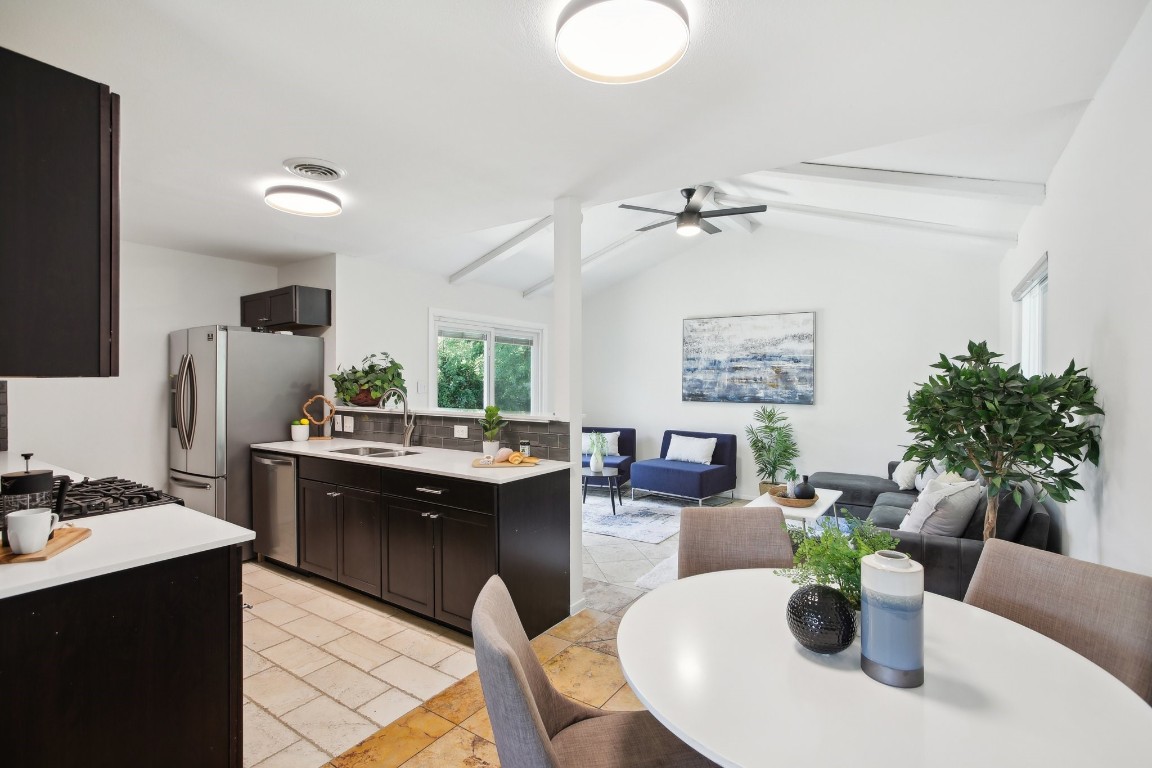 a kitchen with a refrigerator and a dining table