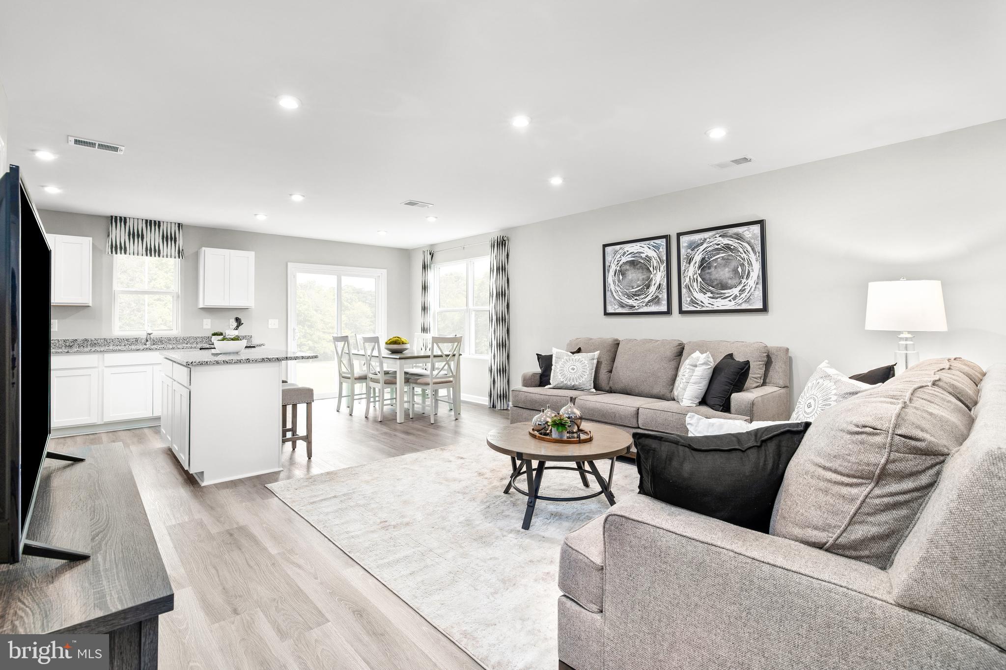 a living room with furniture and view of kitchen