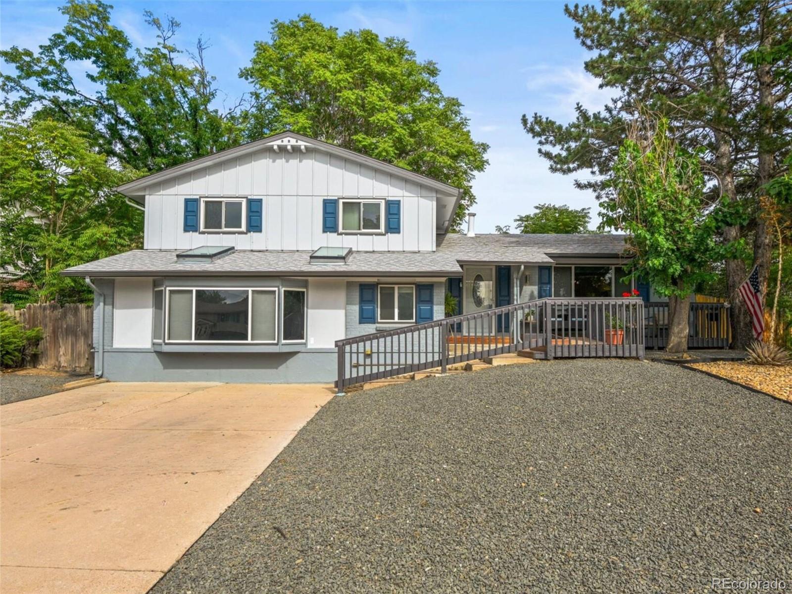 a front view of a house with a garden and trees