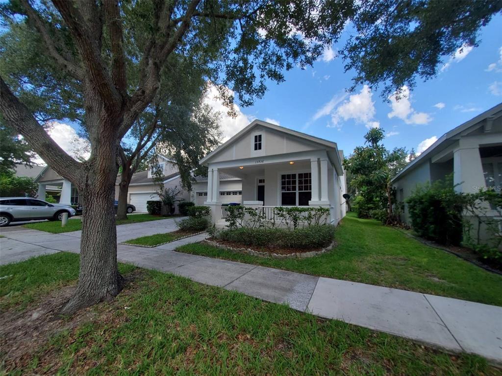 a front view of a house with a garden and trees