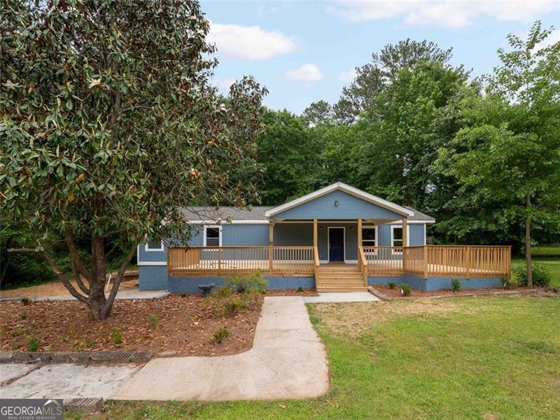 a front view of a house with a yard and trees