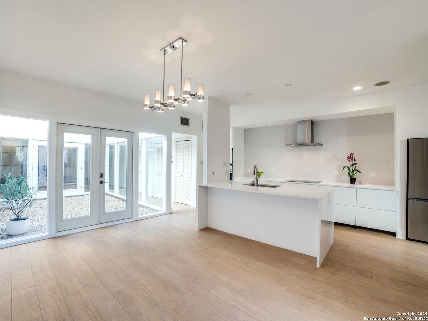 a large white kitchen with a large window