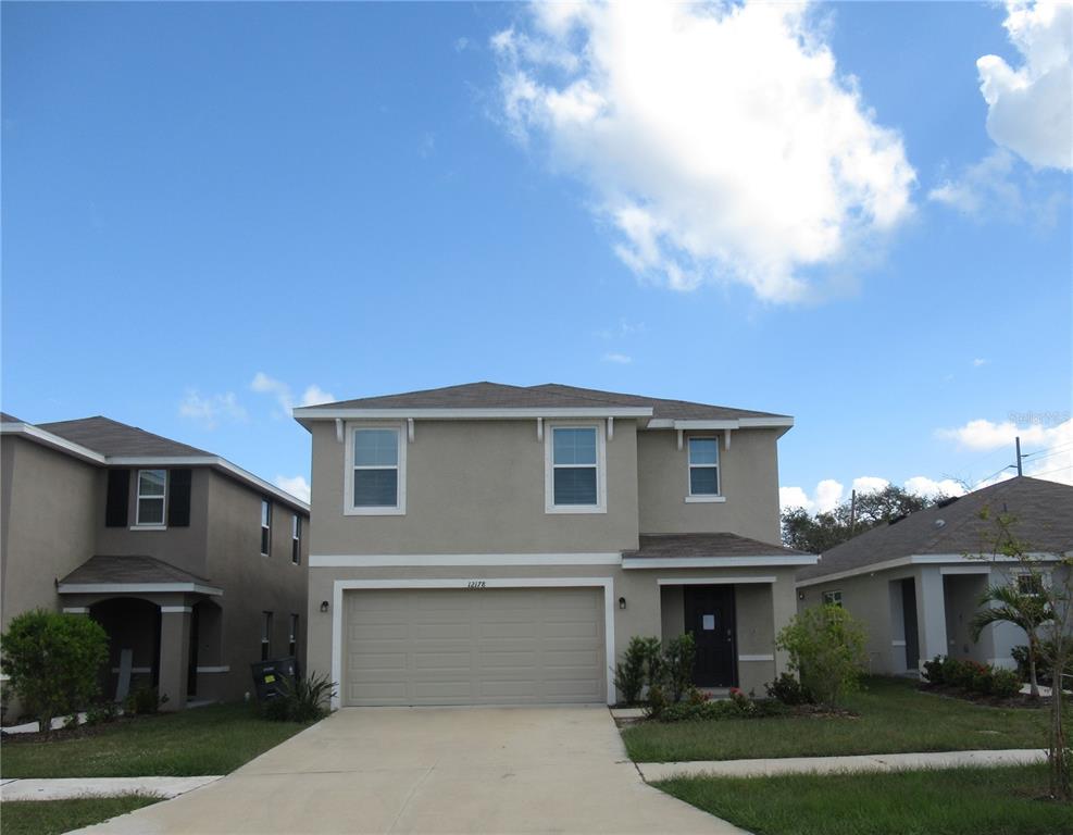 a front view of a house with a yard and garage