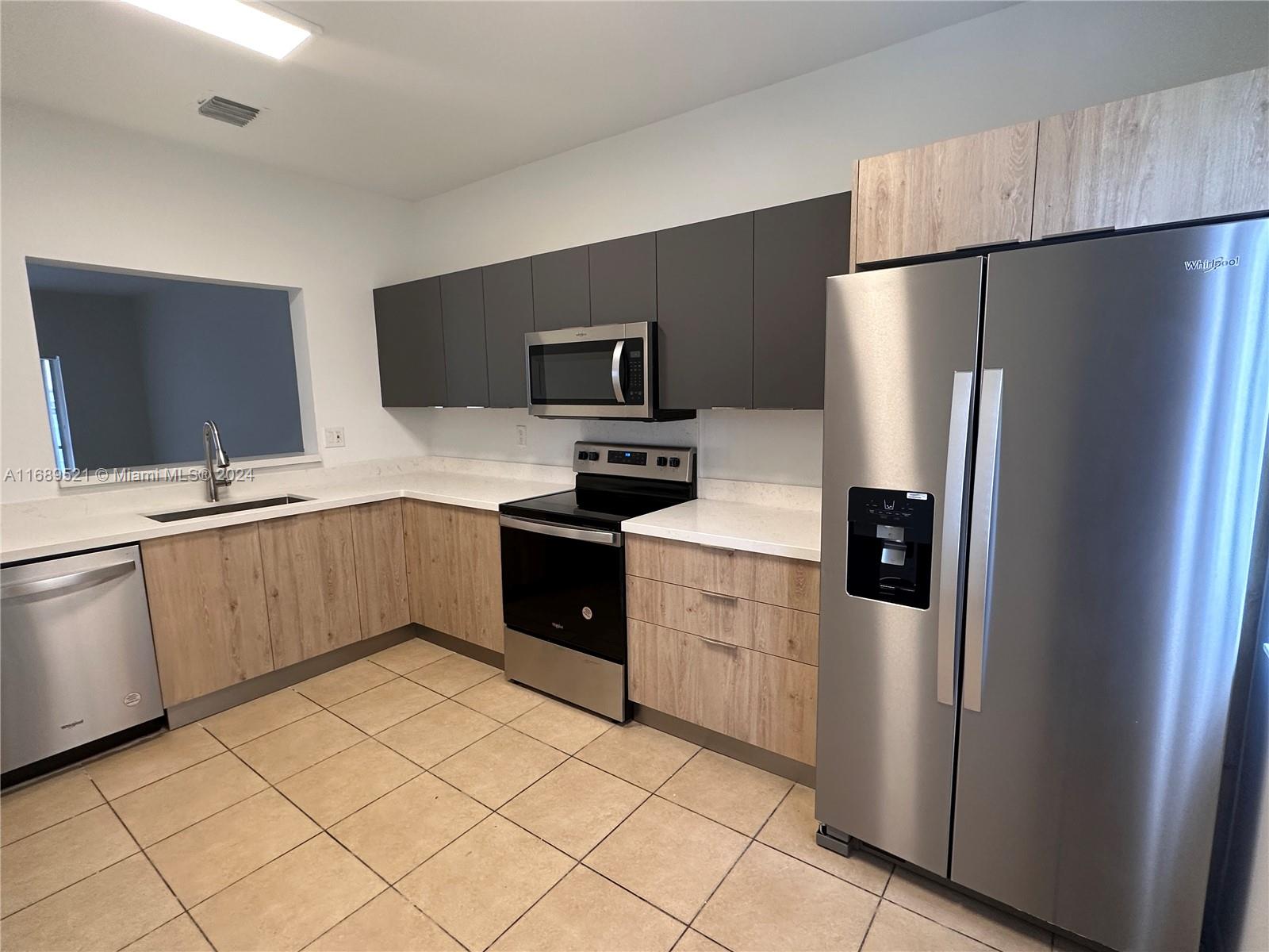 a kitchen with a refrigerator sink and microwave