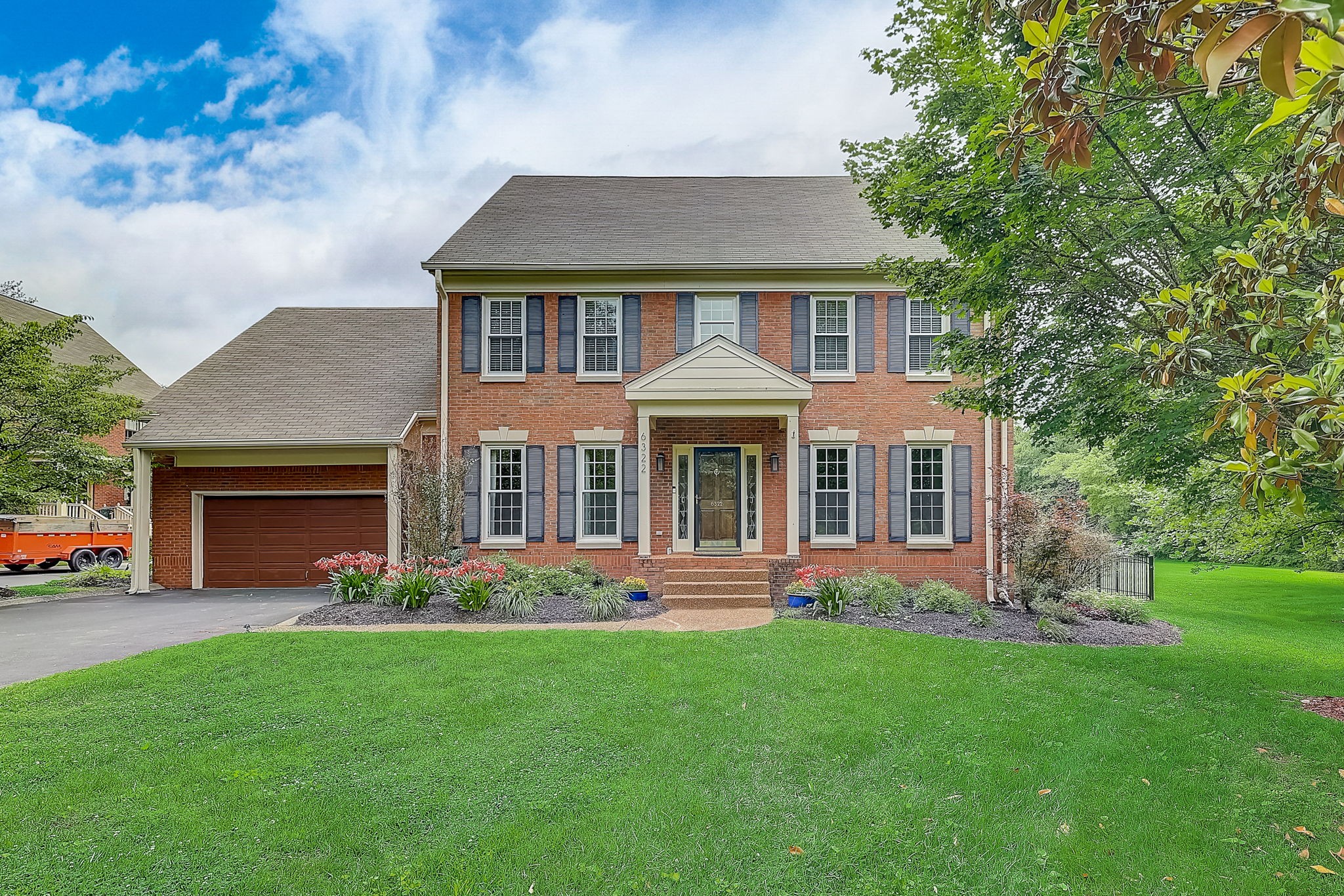 a front view of a house with a garden and yard