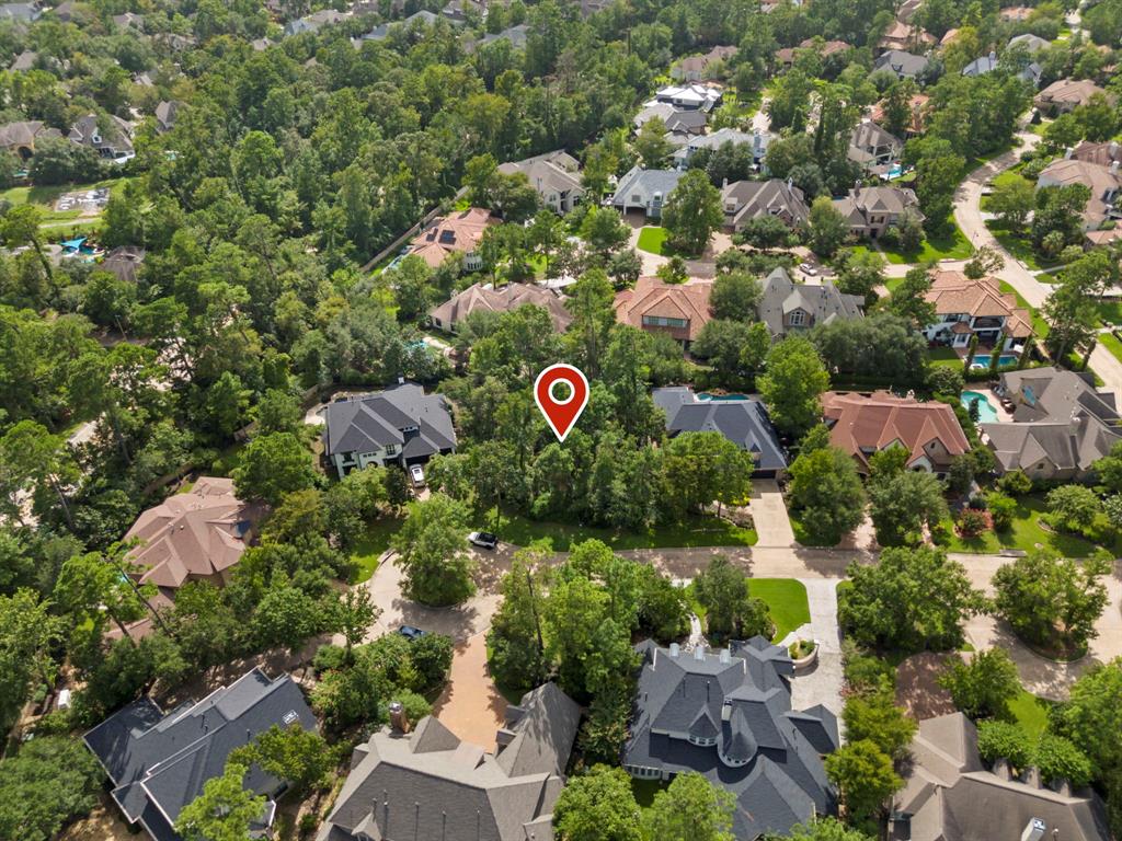 an aerial view of residential houses with outdoor space and trees