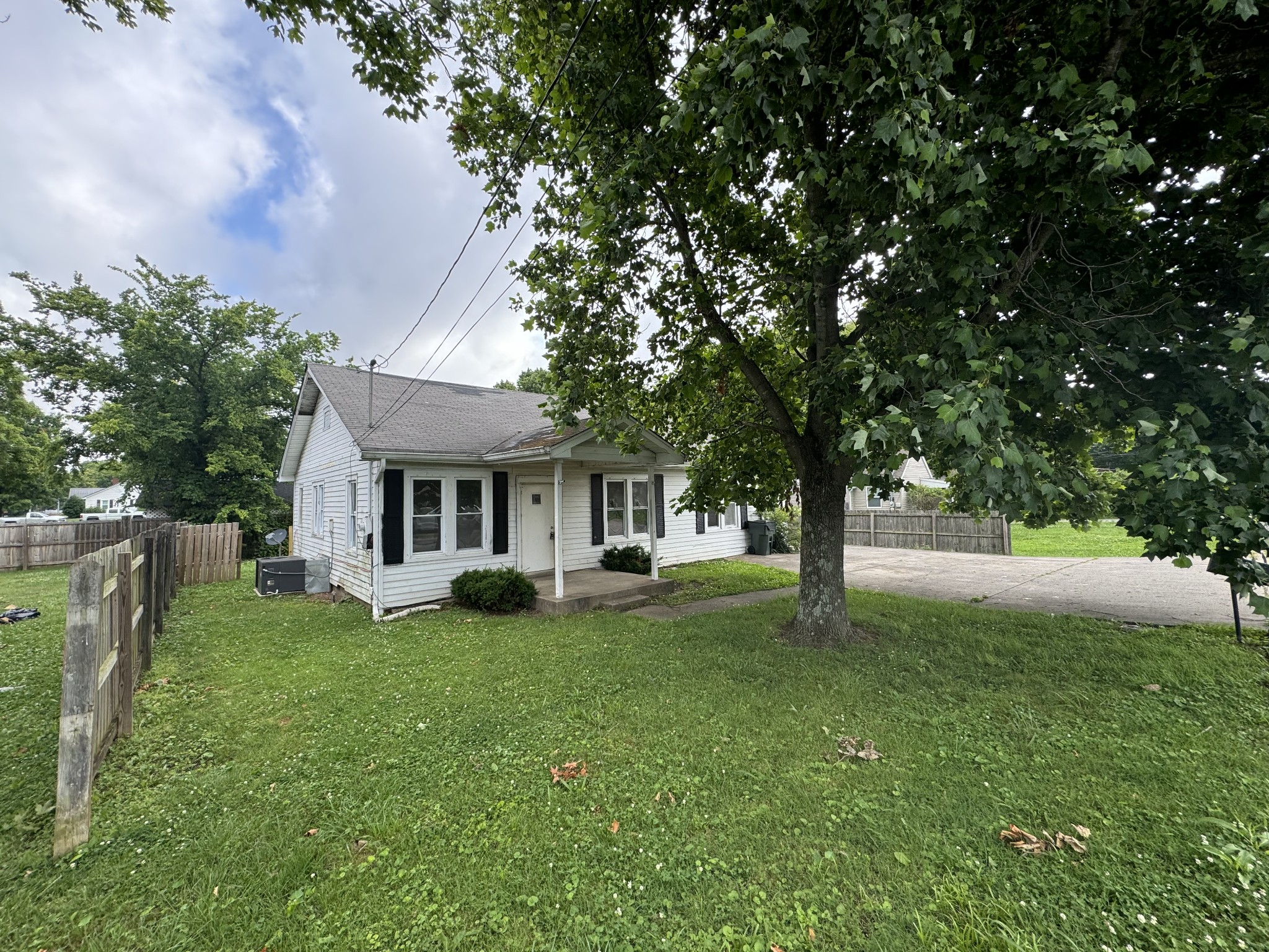 a view of a house with a big yard and large trees