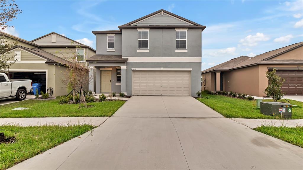 a front view of a house with a yard and garage