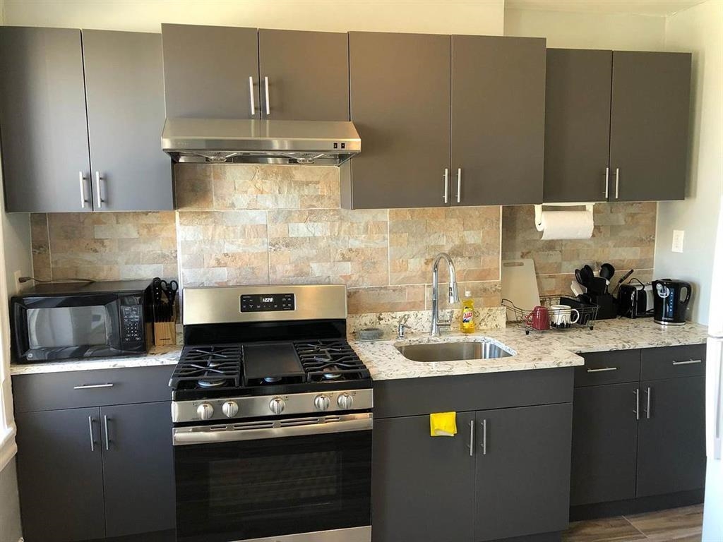 a stove top oven sitting inside of a kitchen