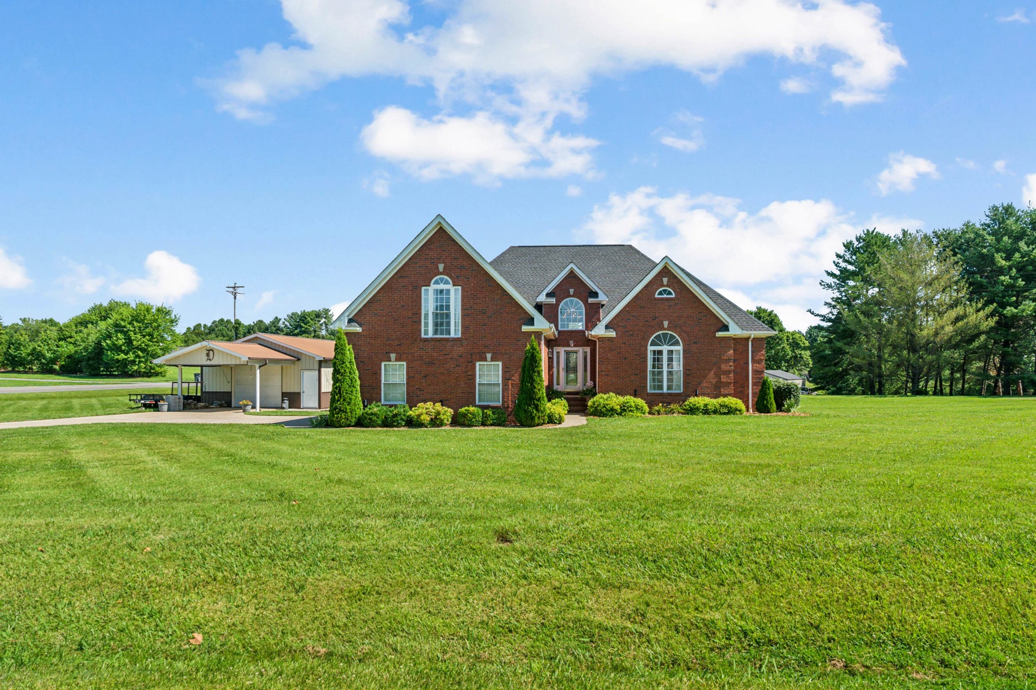 a front view of a house with a yard and trees