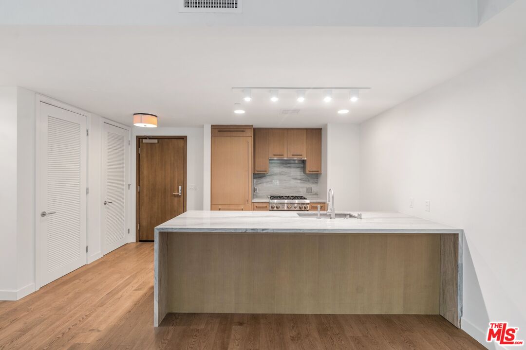 a large room with kitchen island a sink a stove and a refrigerator