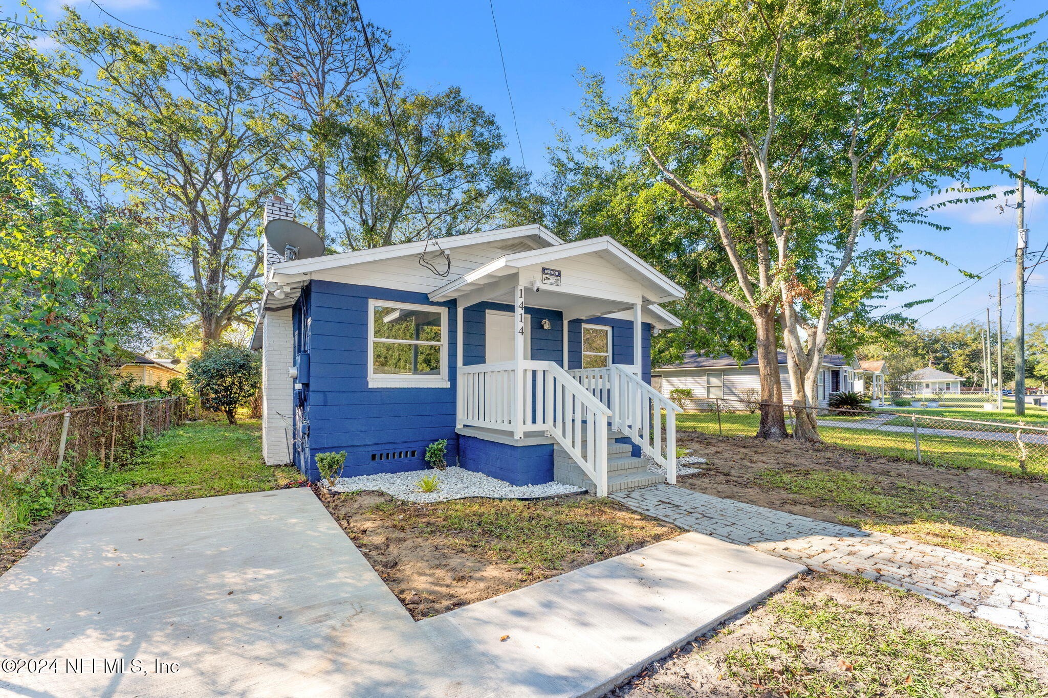 a front view of a house with a yard garden and outdoor seating