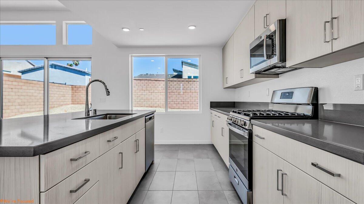 a kitchen with granite countertop a sink stainless steel appliances and cabinets