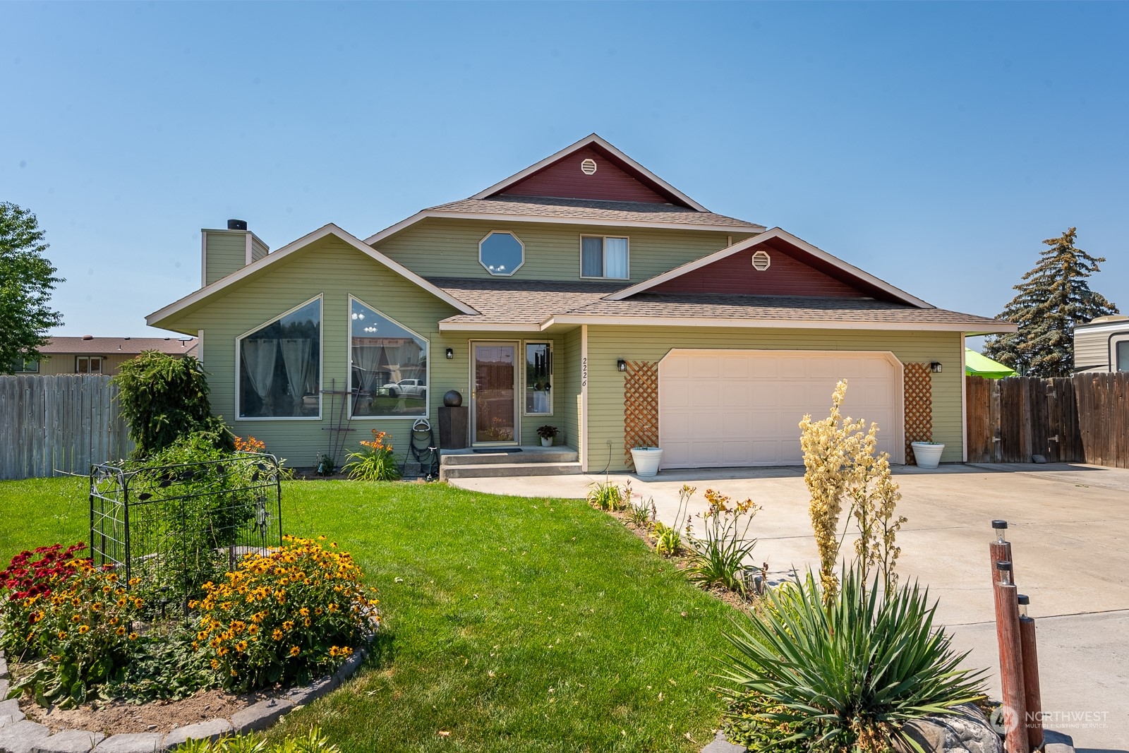 a front view of a house with a yard outdoor seating and garage