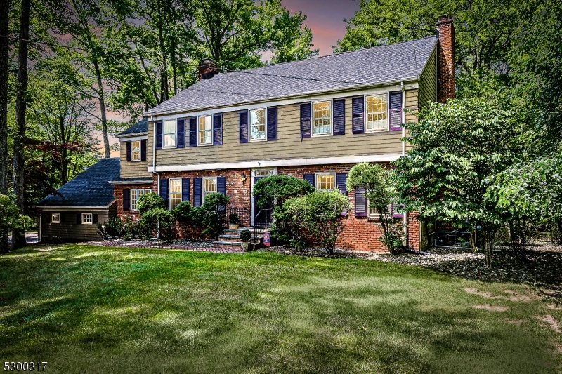 a front view of a house with a yard and trees