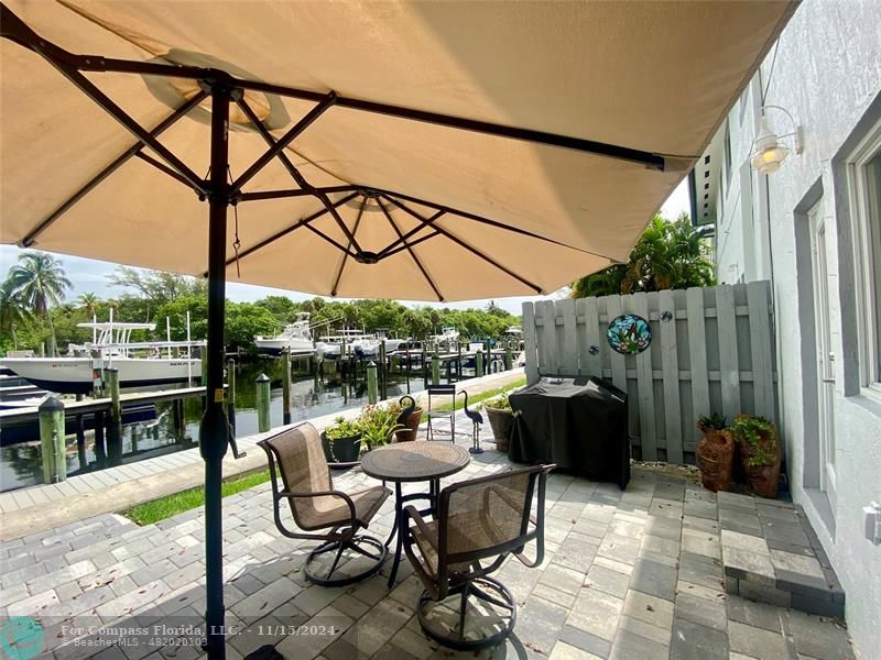 a patio with glass top table and chairs