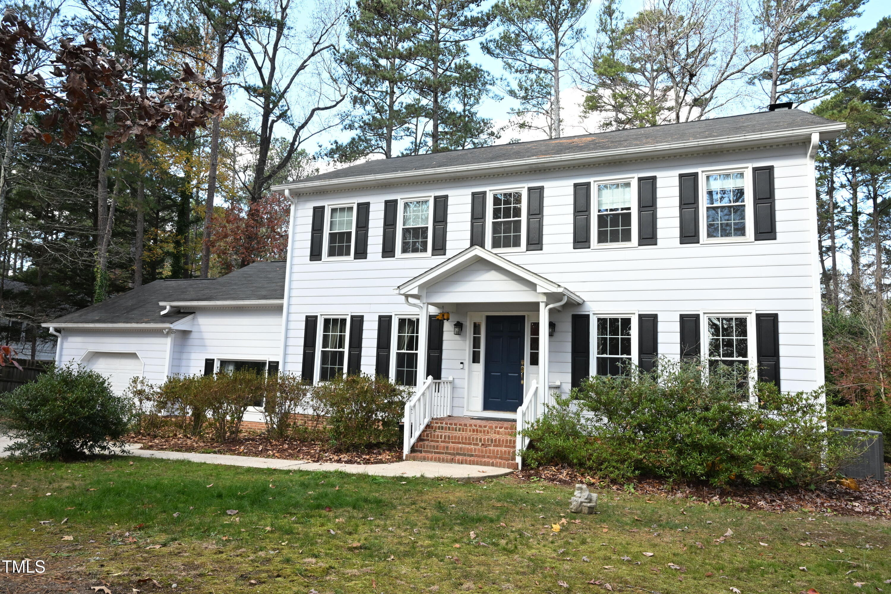 a front view of a house with a yard and potted plants