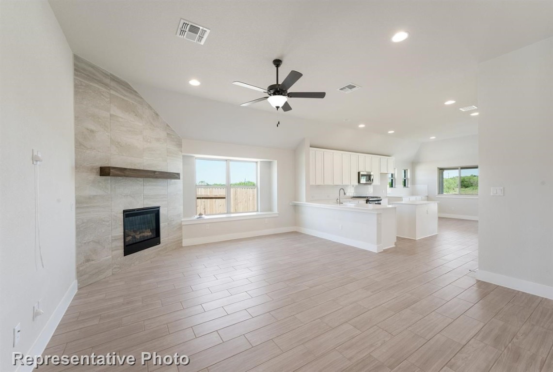 a view of kitchen with cabinets and fireplace