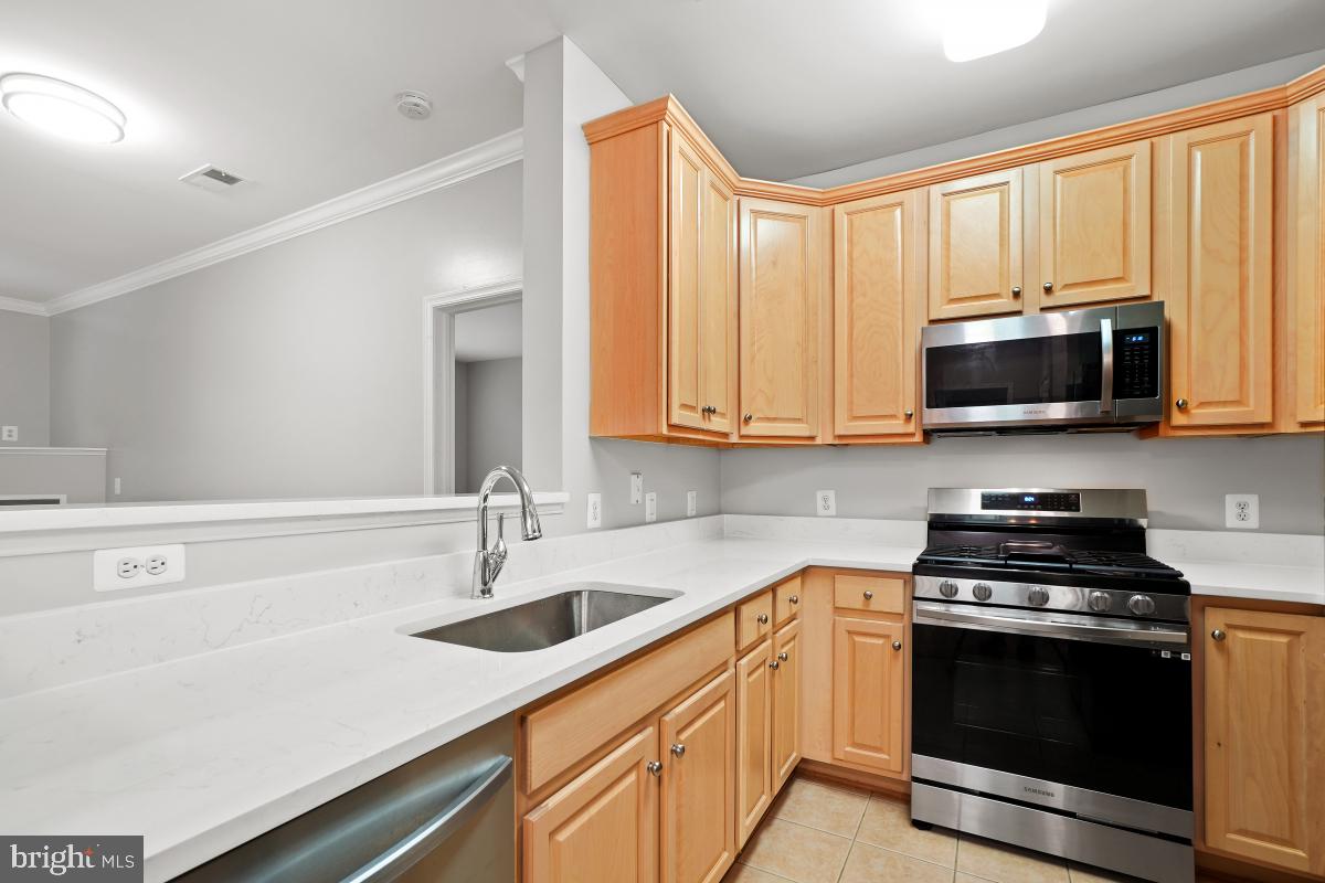 a kitchen with stainless steel appliances wooden cabinets and a sink
