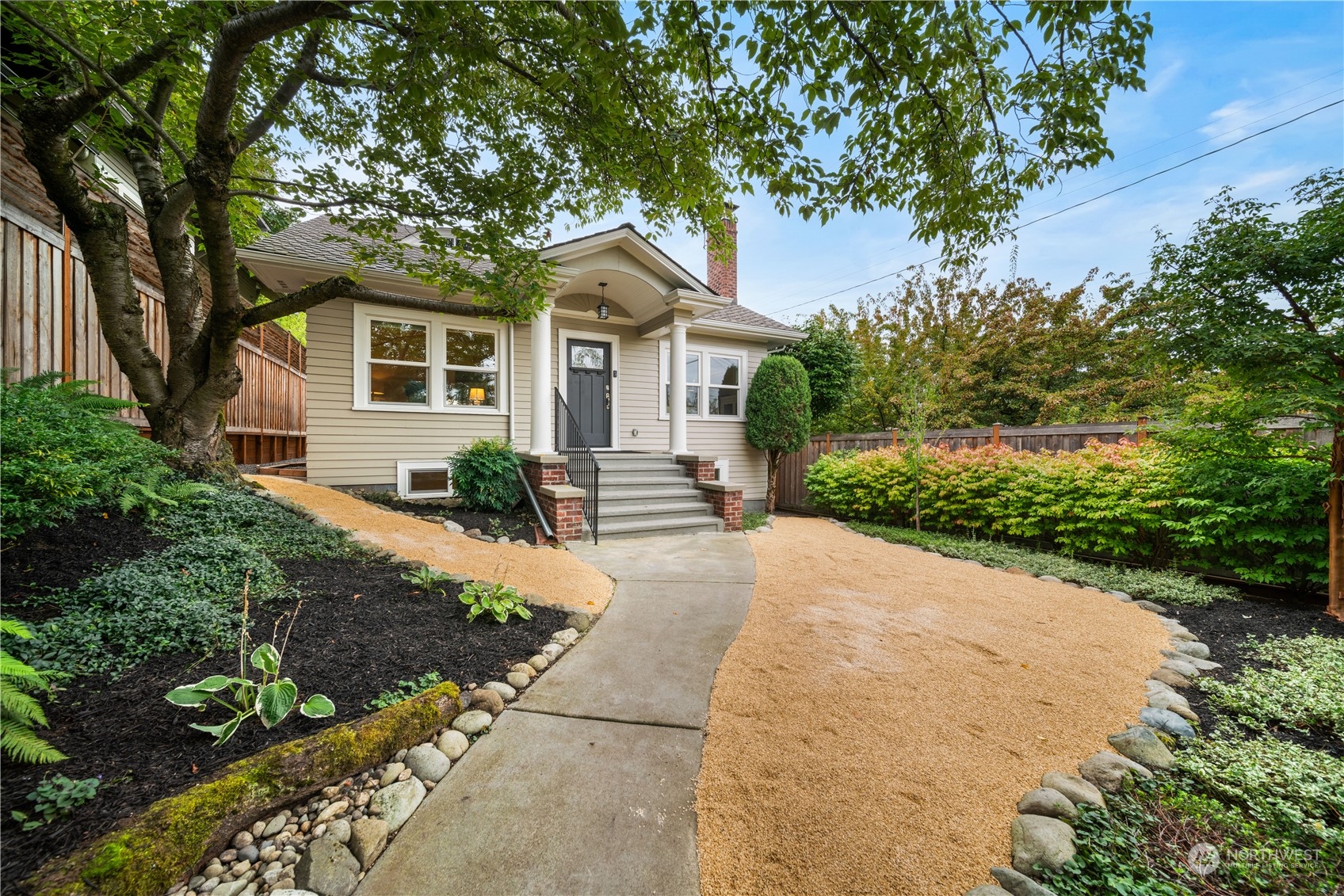 a front view of a house with a yard and trees