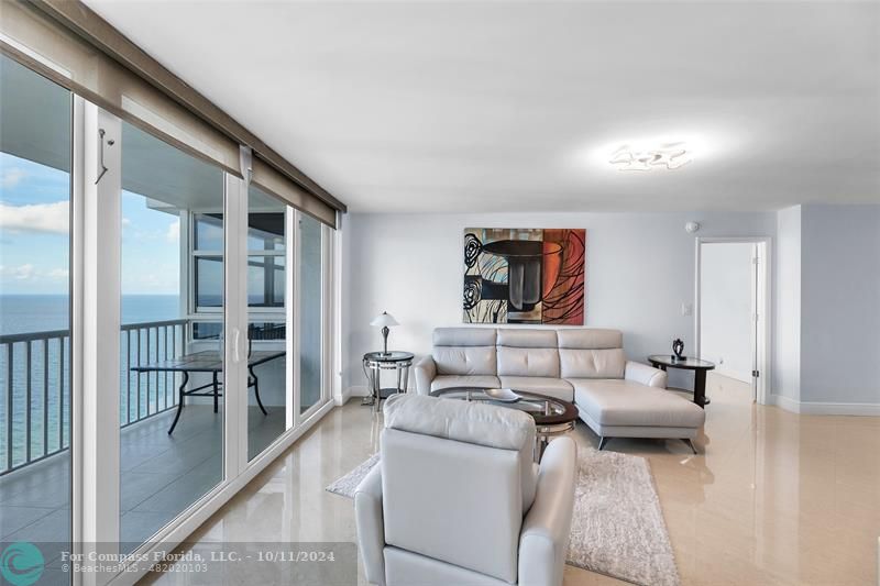 a living room with furniture and a floor to ceiling window