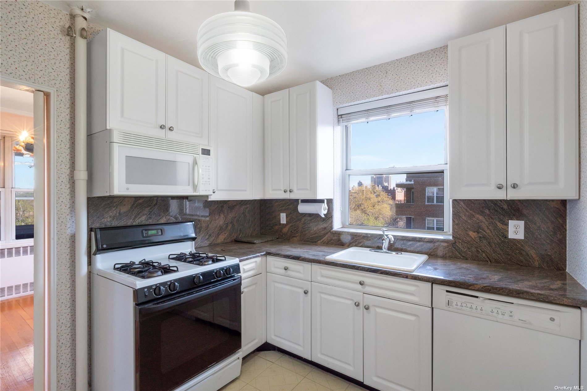 a kitchen with granite countertop a sink stainless steel appliances and cabinets