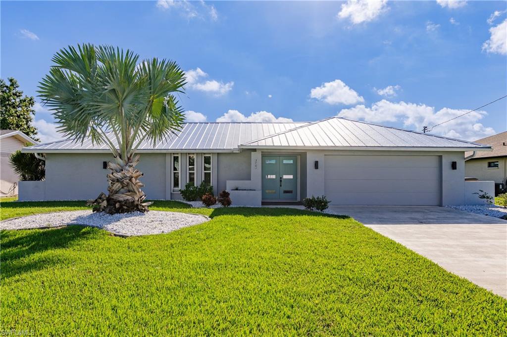 Single story home featuring a garage, a front yard, and french doors