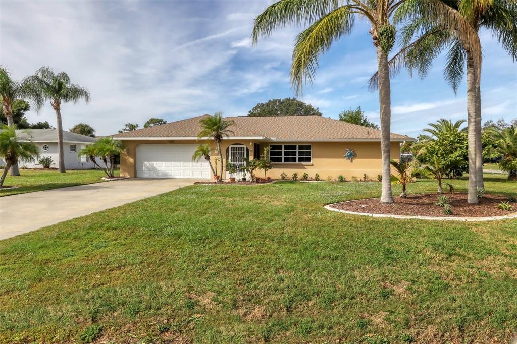 a view of a house with a yard and palm trees