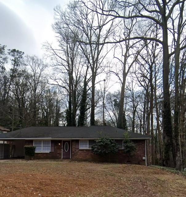 a front view of house with yard and trees in the background