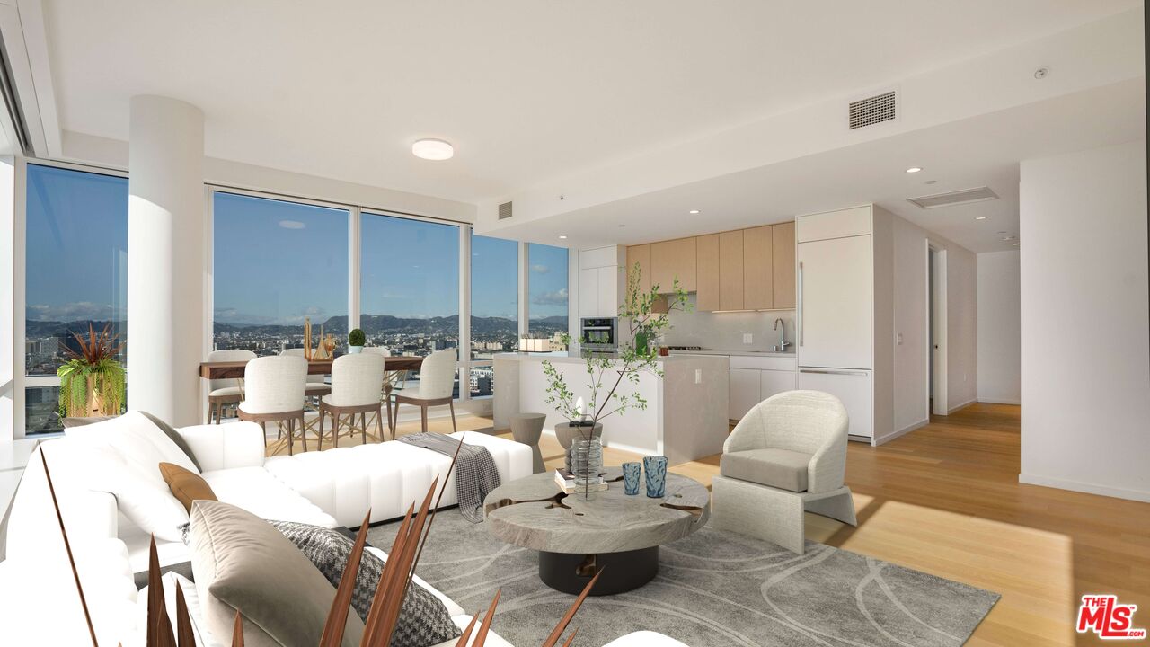 a living room with lots of furniture kitchen view and a table