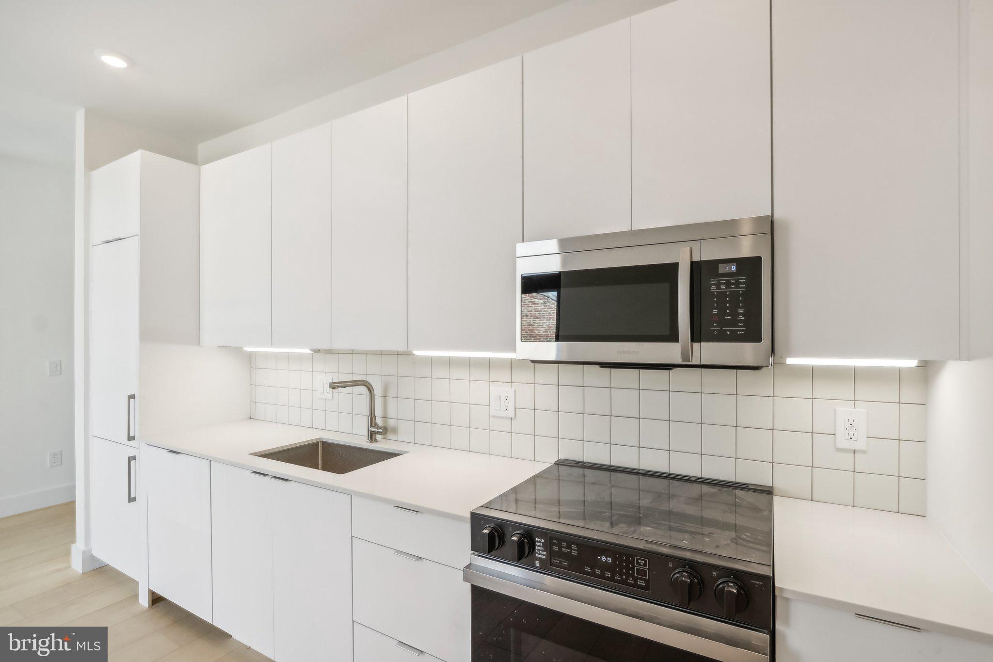 a kitchen with stainless steel appliances a sink a stove and microwave