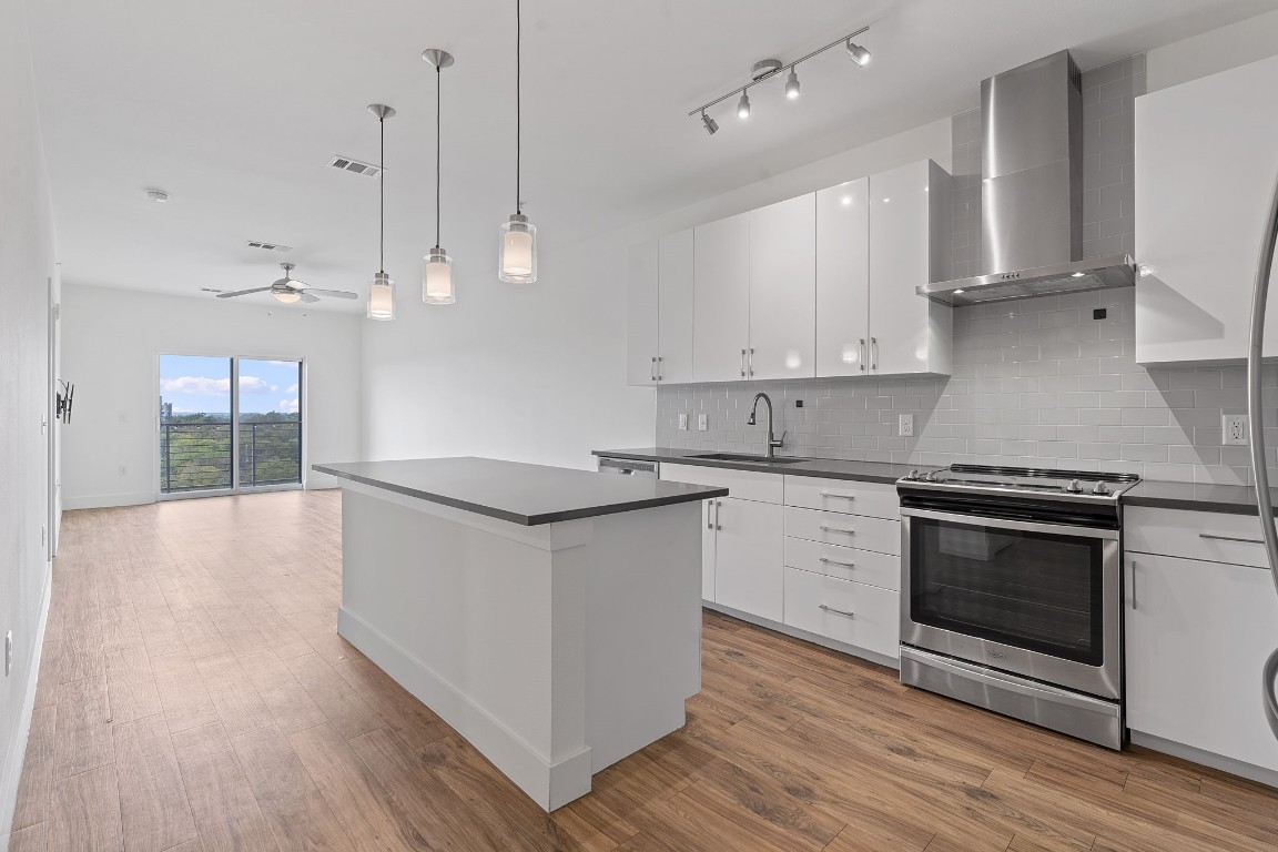 a kitchen with stainless steel appliances granite countertop a stove a sink and a refrigerator