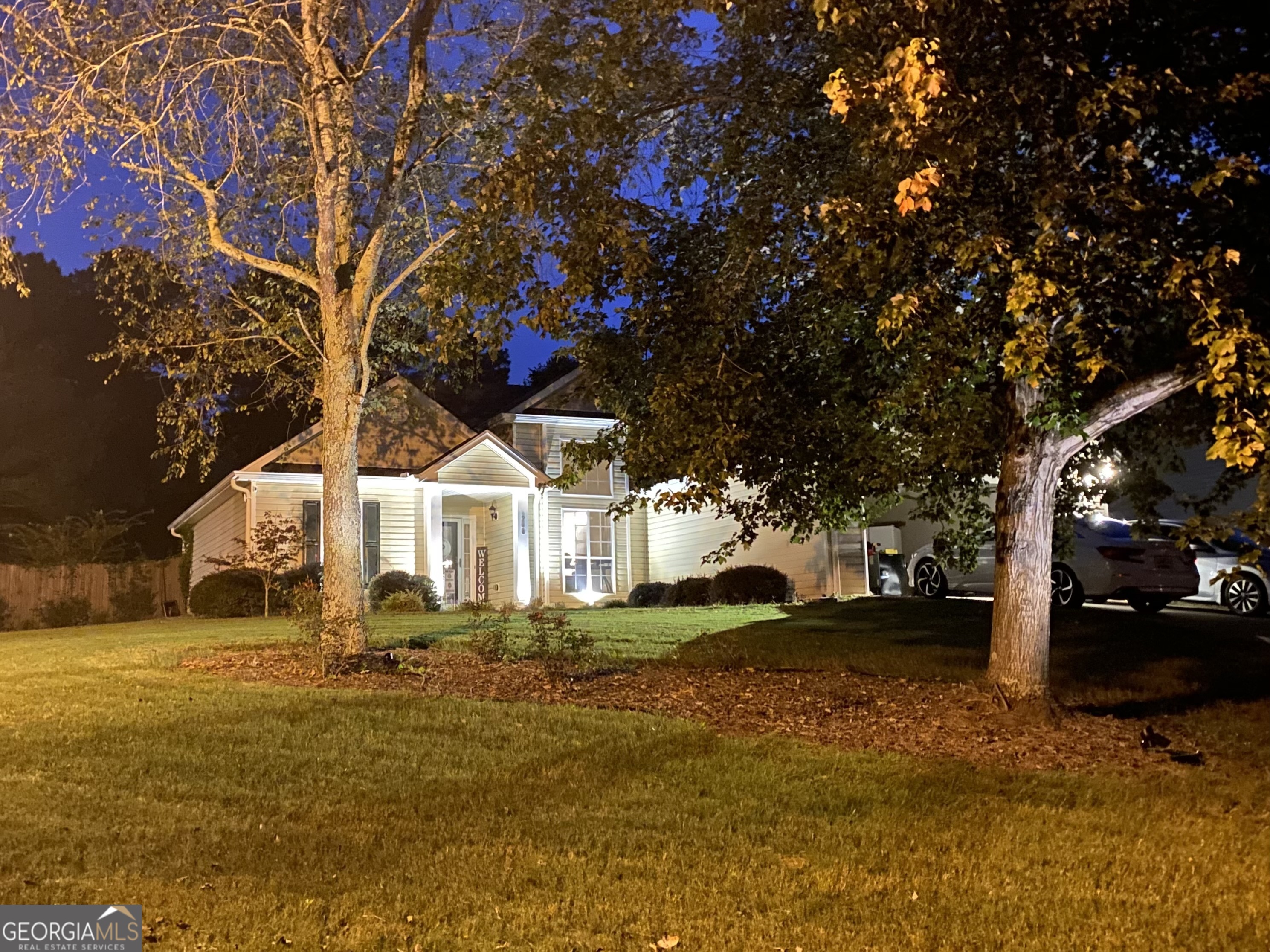 a front view of a house with a yard tree and outdoor seating