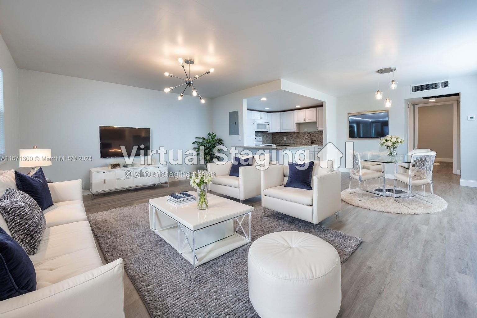 a living room with furniture a flat screen tv and kitchen view