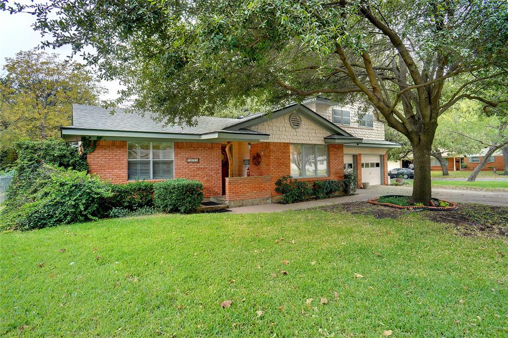 a front view of a house with a yard and trees