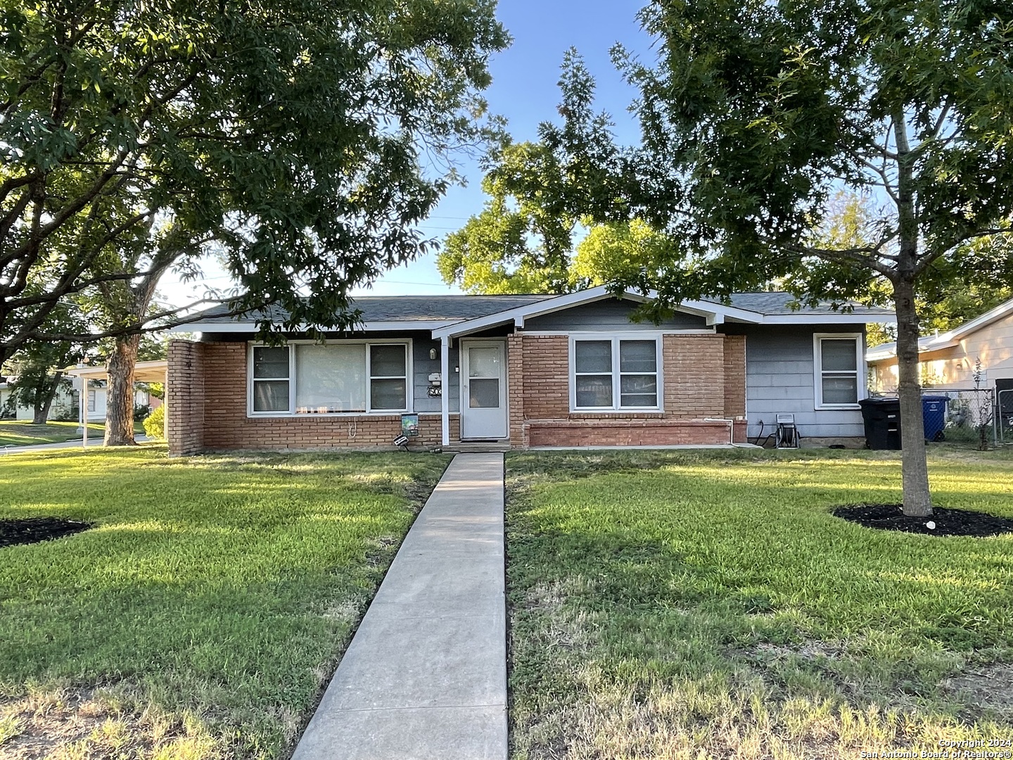 a front view of a house with a yard and trees