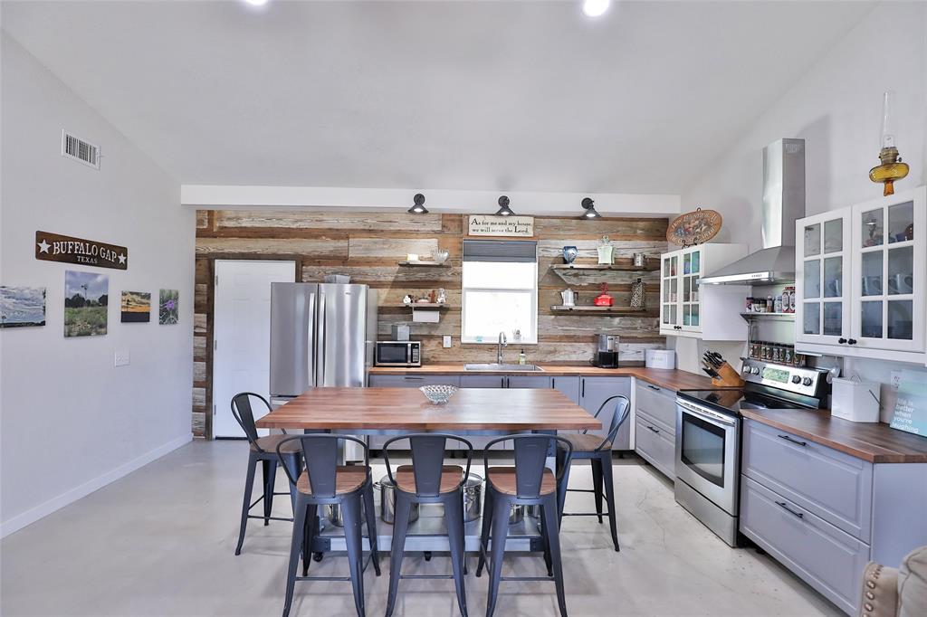 a kitchen with granite countertop a table chairs stove and cabinets