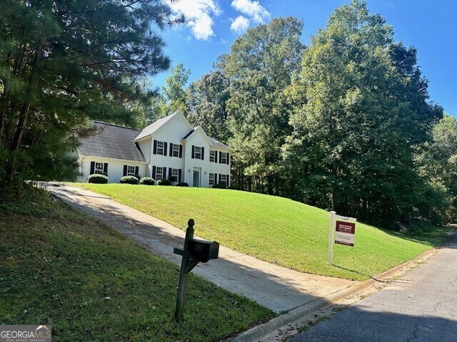 a view of house with a yard