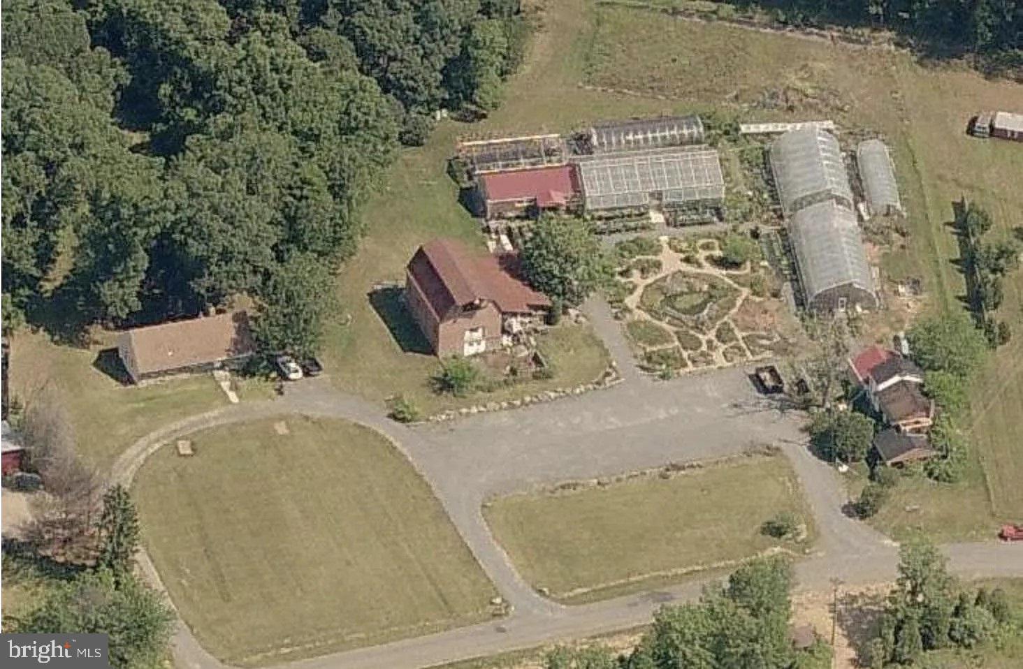 an aerial view of a house with a yard and large trees