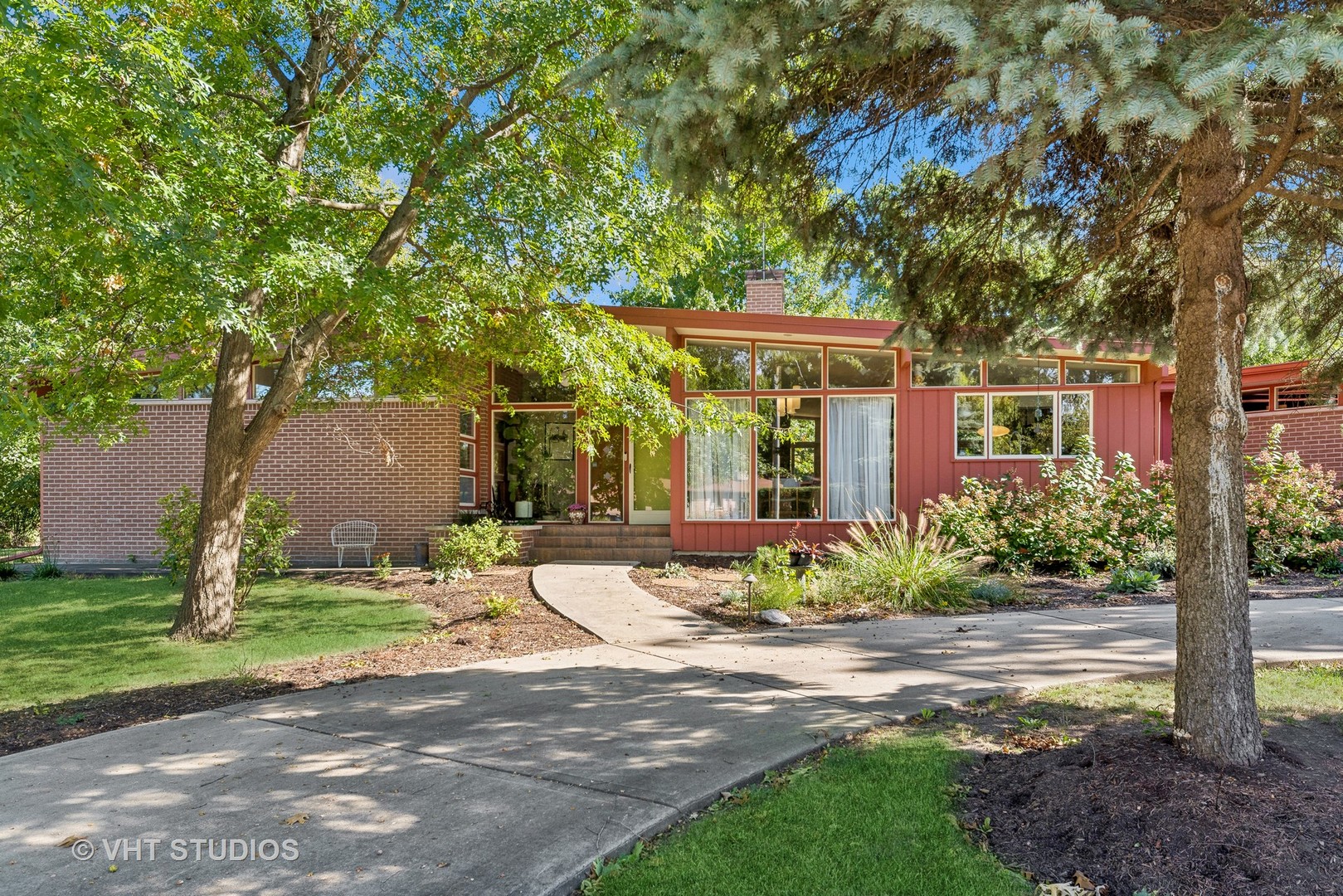 a front view of a house with a yard and potted plants