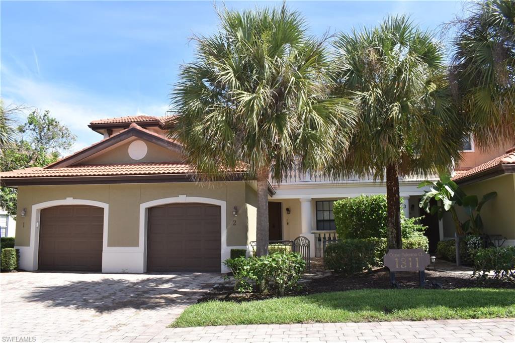 a front view of a house with yard and trees