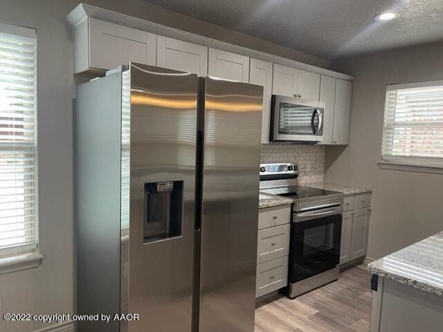 a metallic refrigerator freezer sitting in a kitchen