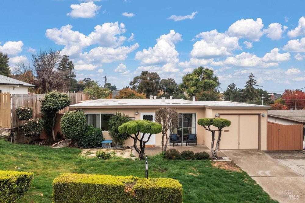 a view of a house with backyard sitting area and garden