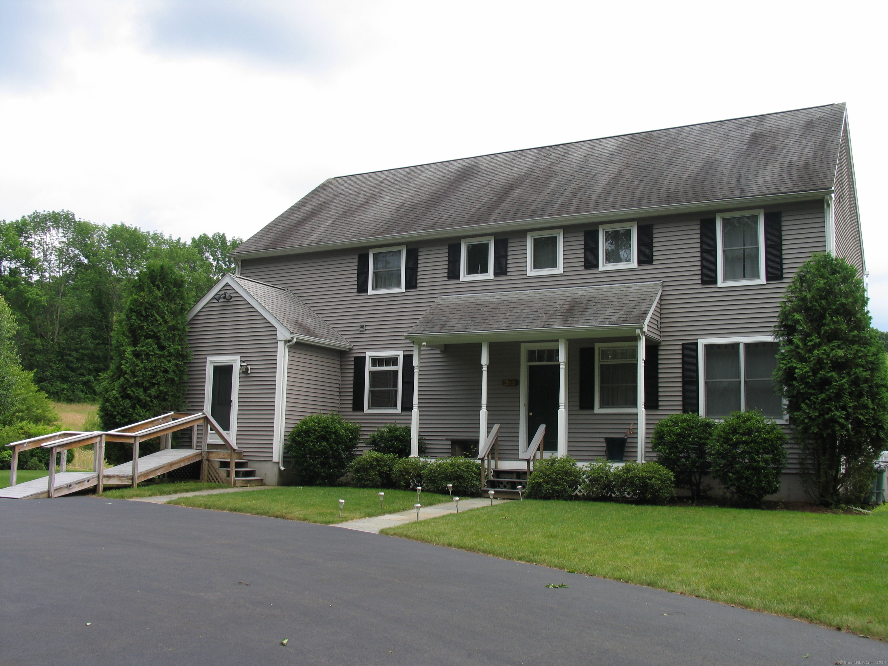 a front view of a house with a yard and trees