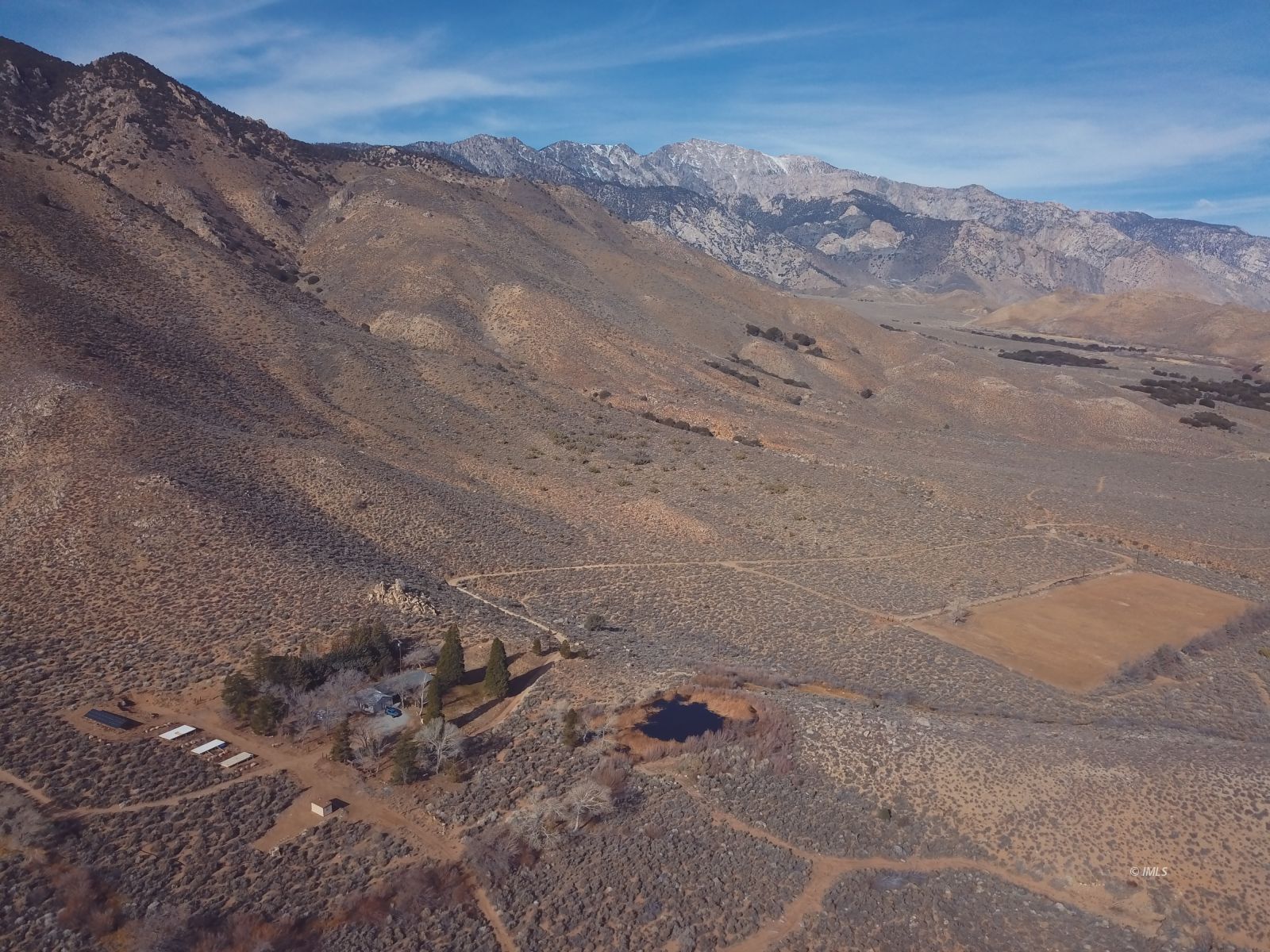 a view of a dry yard with mountains in the background